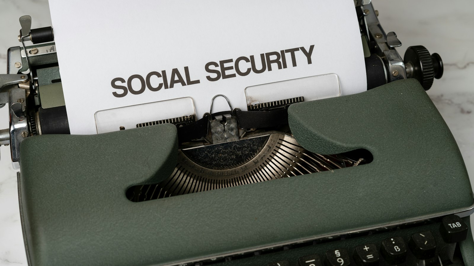 A close up of a typewriter with a paper that says social security