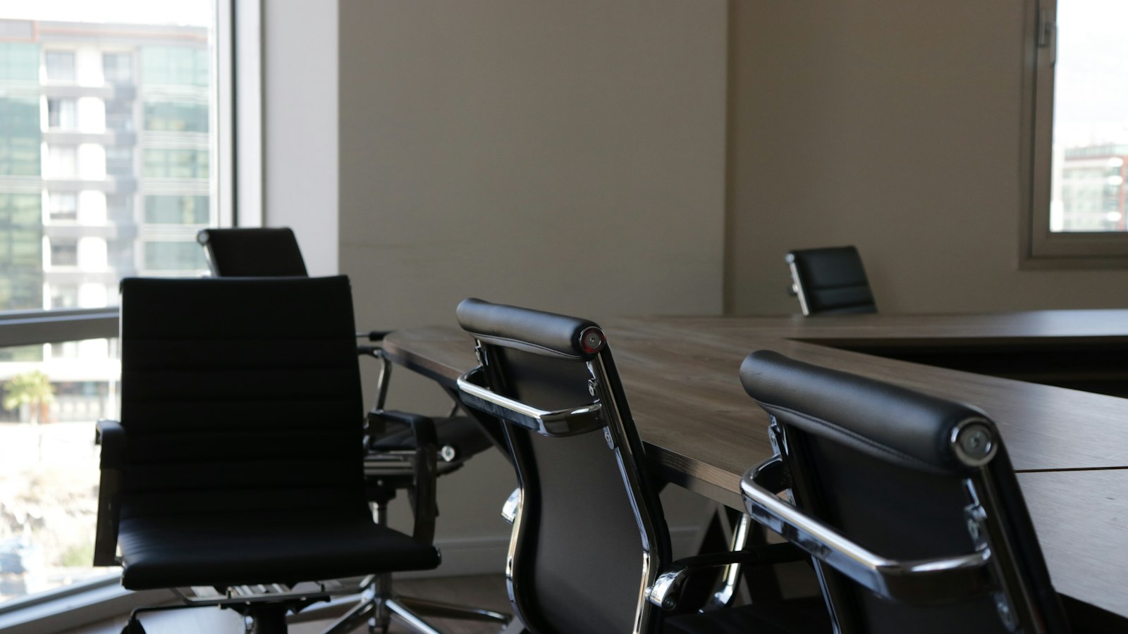 Five black rolling chars front of desk